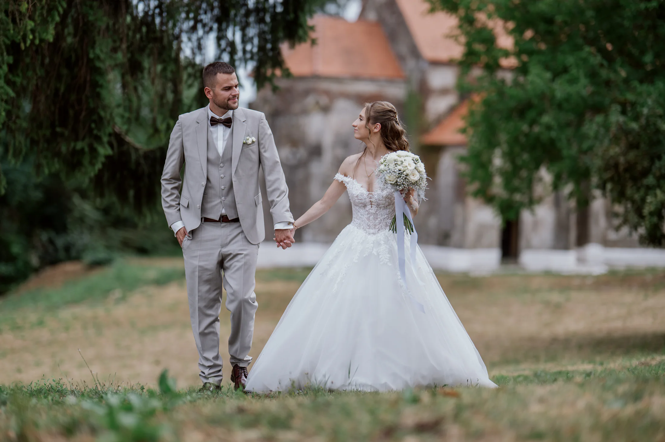 Bride and groom walking through a garden